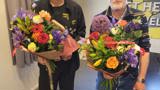 Twee mannen met bloemen.